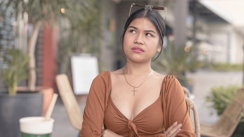 A woman rolling her eyes with ana nnoyed expression