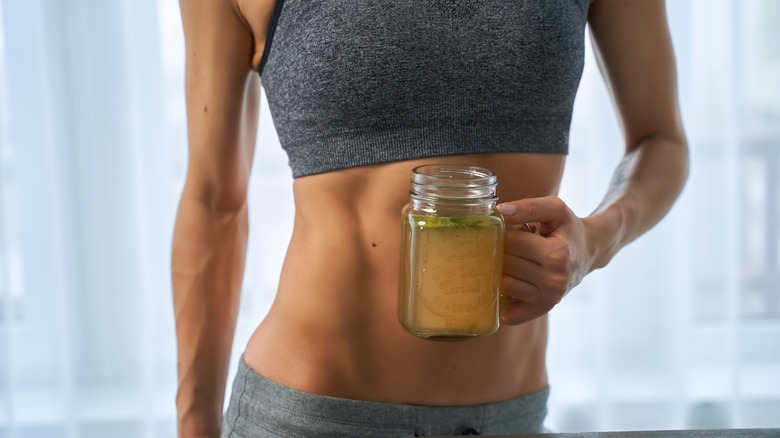 Person holding glass of broth