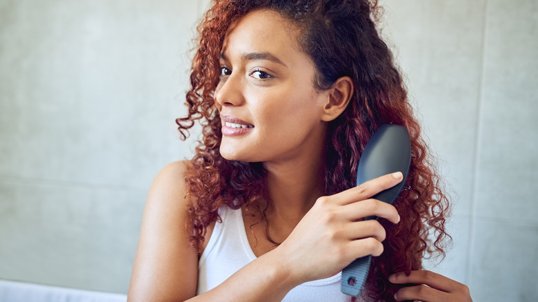 woman brushing curly hair