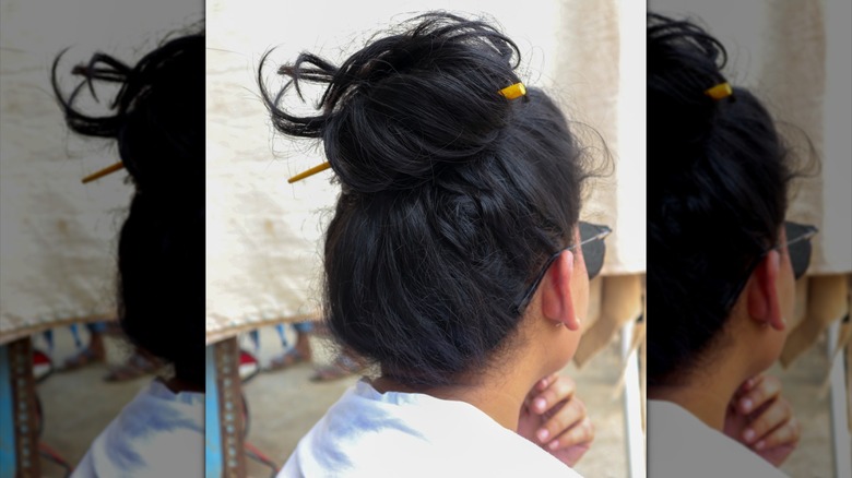 A messy bun with parts falling out of it.