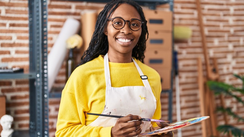young woman smiling with paint