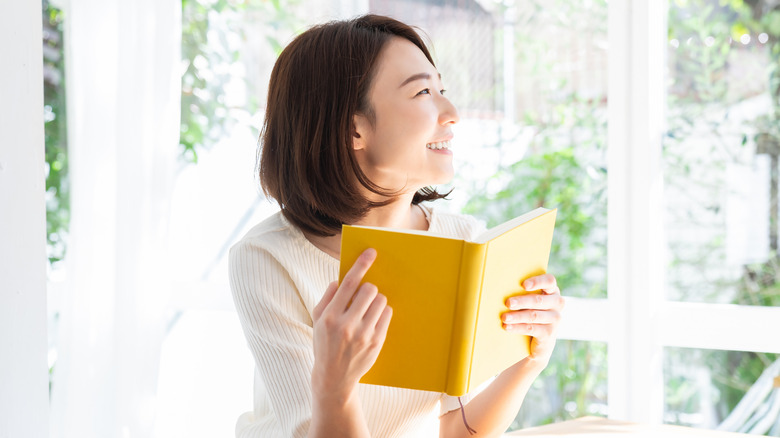 woman smiling while reading