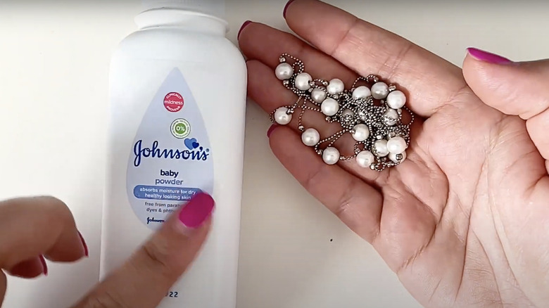 woman using powder on necklace