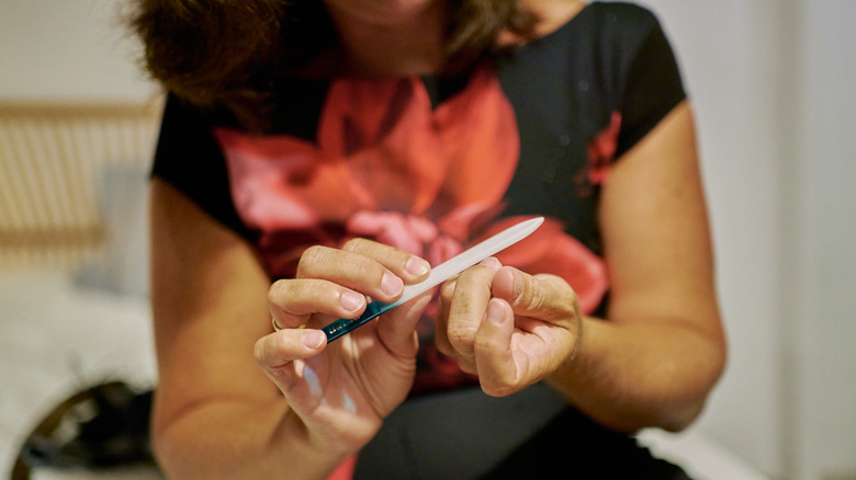 A person filing their natural nails