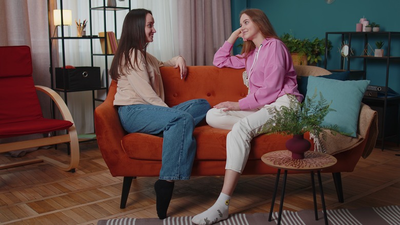 Couple converses on sofa