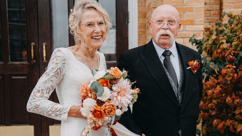 A happy bride and groom holding flowers