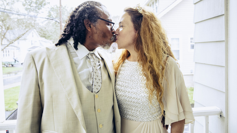 Older newlyweds kissing on their wedding day