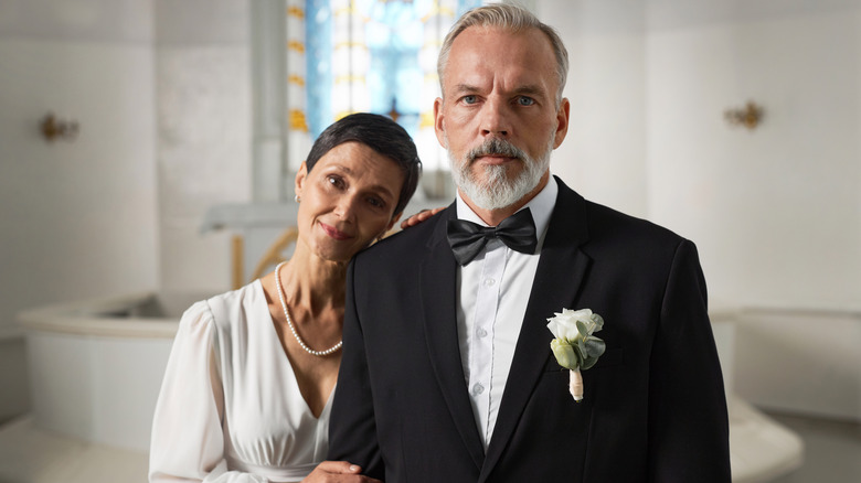 A senior newlywed couple posing on their wedding day