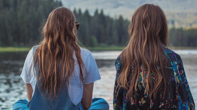 friends sitting by a lake