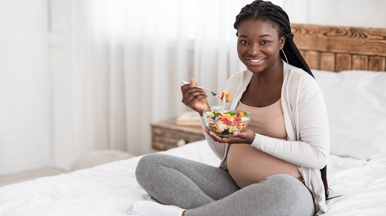 Pregnant woman eating salad