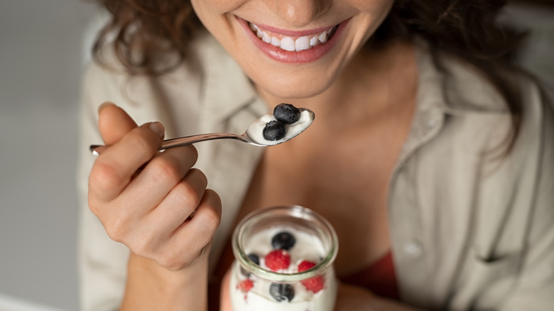 woman eating fresh fruit parfait