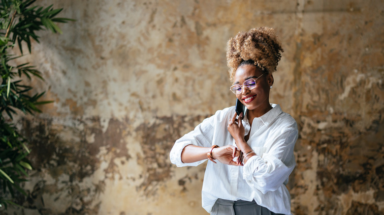 Woman on phone and checking watch