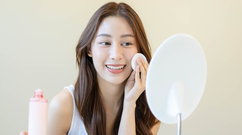 Woman applying toner.