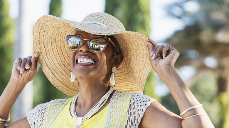 Woman wearing sunglasses and wide-brimmed hat