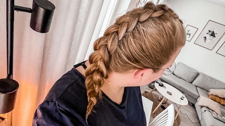 Woman models Dutch braid