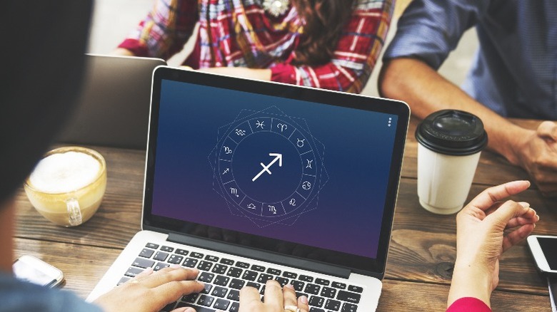 Co-workers working together around laptop