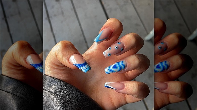 woman's hands with blue mismatched mani
