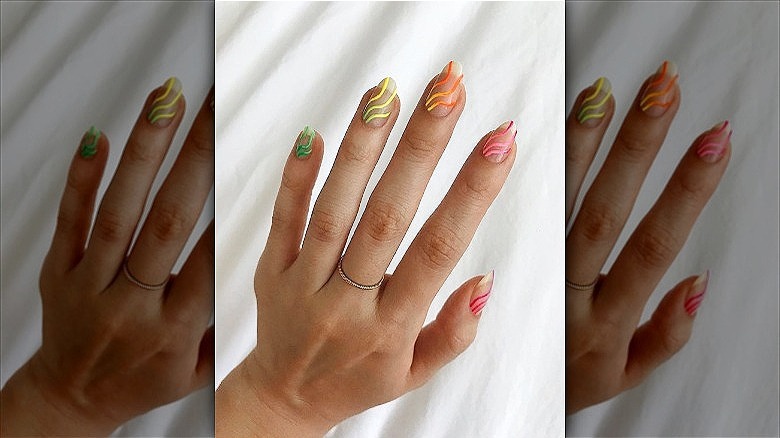 hands with mismatched ombre squiggle manicure