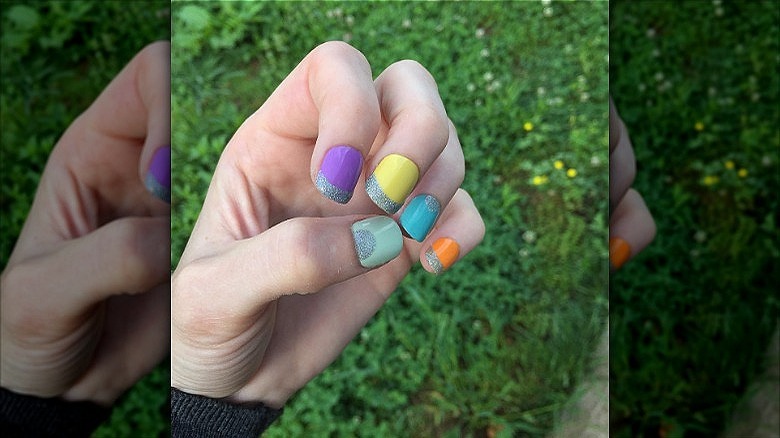 hand with bright mismatched nails