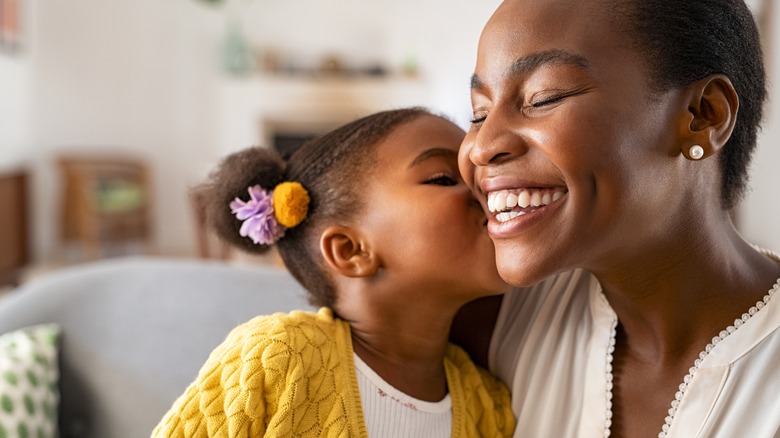 kid kissing woman's cheek