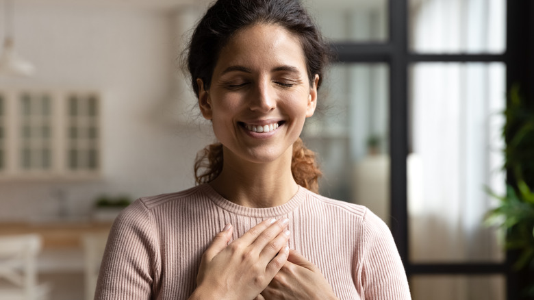 woman with hands on chest