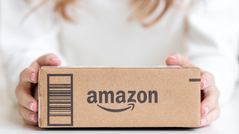 A woman holding an Amazon box