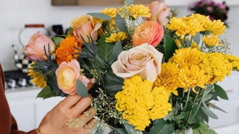 Woman looking at floral arrangement 