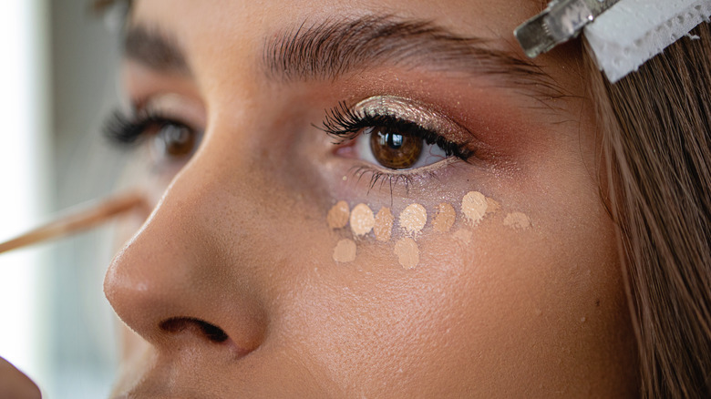 Woman applying concealer