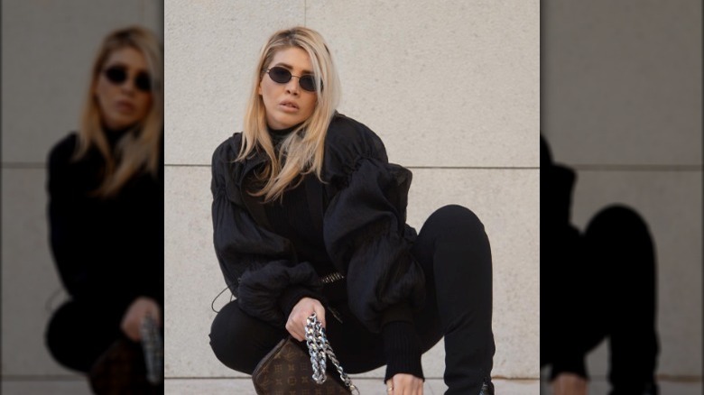 Woman wearing black circular sunglasses