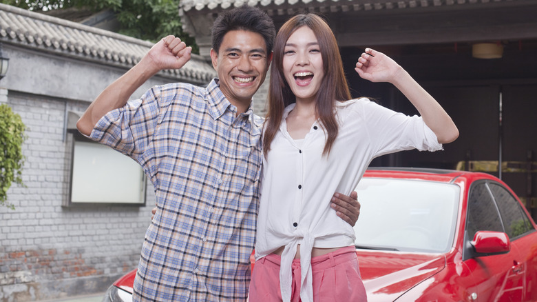 Couple standing in front of car