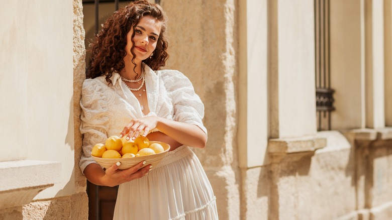 Woman linen shirt skirt holding lemons