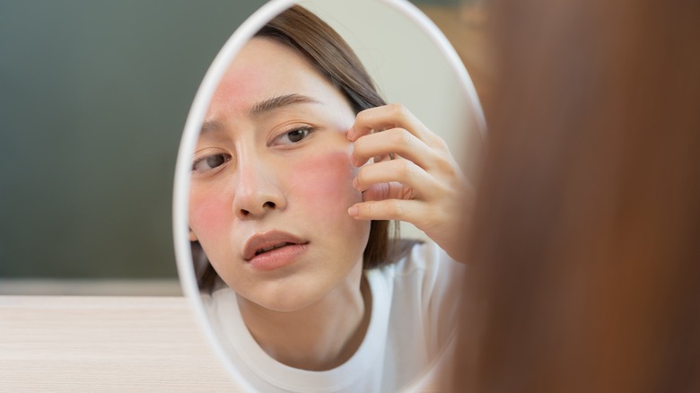 Woman scratching her face