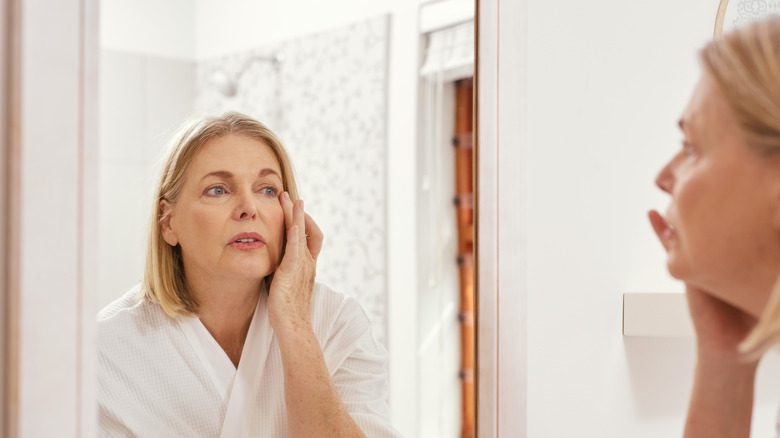 Woman looking at eyes in mirror