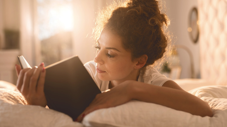 Woman reading book in bed