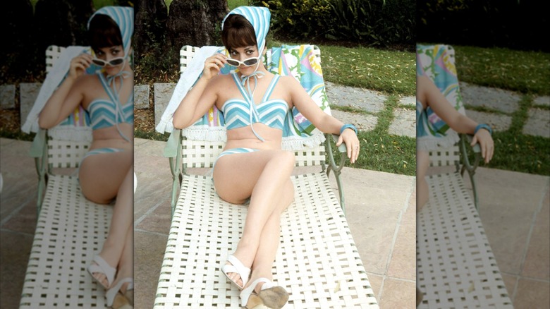 Natalie Wood lounging on a chair by the pool.
