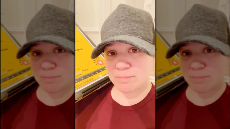 Kelly Clarkson with her hair tucked into a cap