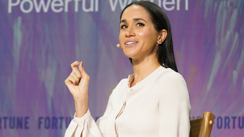 Meghan Markle speaking at an event with self-done makeup