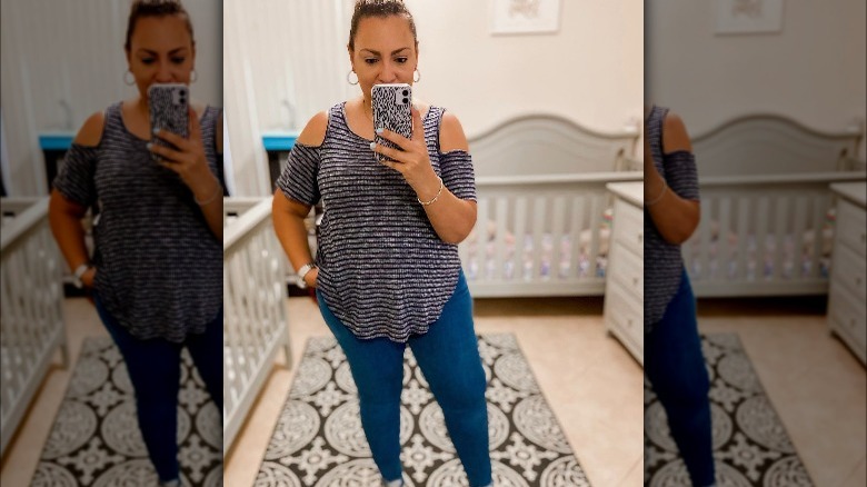 Woman poses in could-shoulder shirt