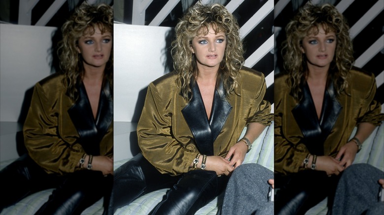 Bonnie Tyler in the '80s wearing black leather pants with big curls