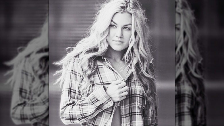 Erika Kirk striking a sultry pose while wearing a flannel shirt