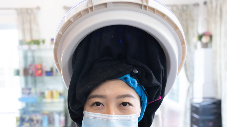 woman using salon hair steamer