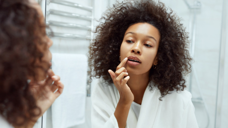 Woman checking lips in mirror