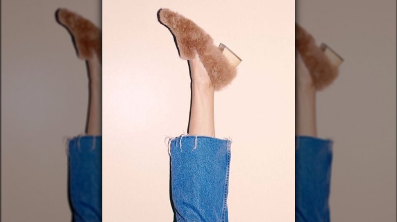 Foot wearing pink furry flats