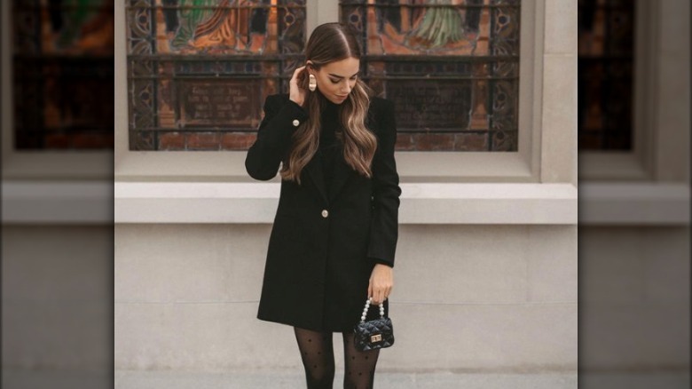 Woman holding black tiny purse