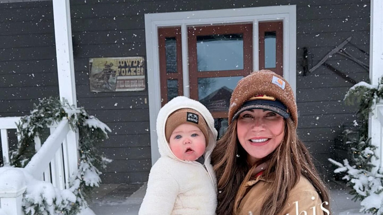 Kristi Noem holding a baby in the snow without makeup