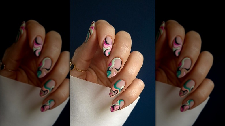 Close up shot of a manicure featuring colorful swirls.