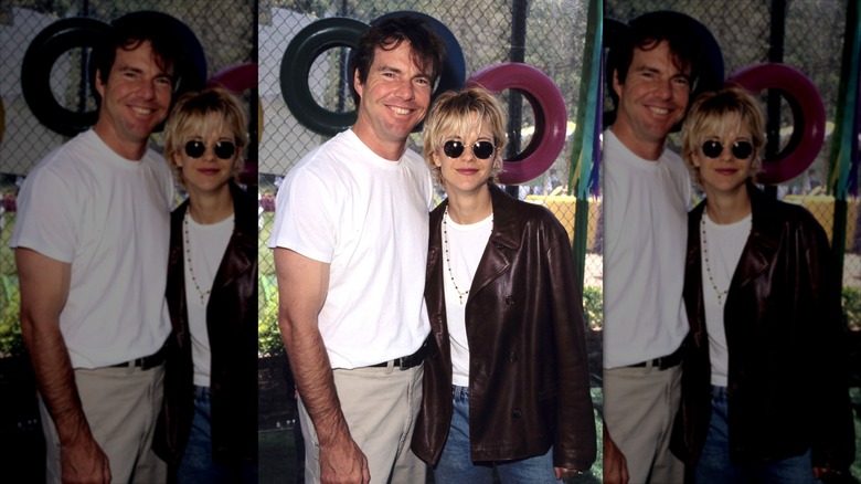 Dennis Quaid in a white shirt and kakis posing with Meg Ryan wearing a brown leather jacket.