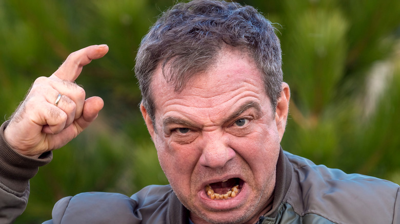 Older man shouting and pointing finger