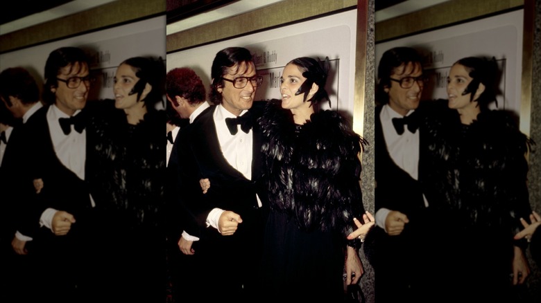 Ali MacGraw wearing a feathery outfit and Robert Evans in a suit at the premiere of "The Godfather."