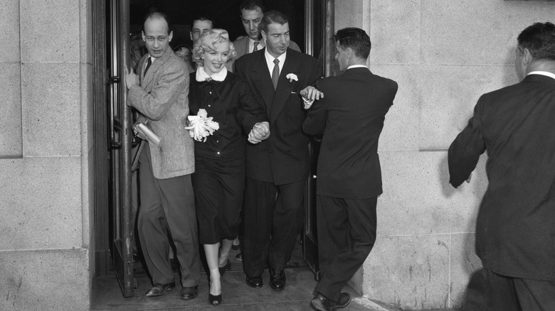 Marilyn Monroe and former Yankee great Joe Di Maggio press through a crowd of newsmen after their marriage in the office of Municipal Judge Charles Peery in San Francisco City Hall January 14